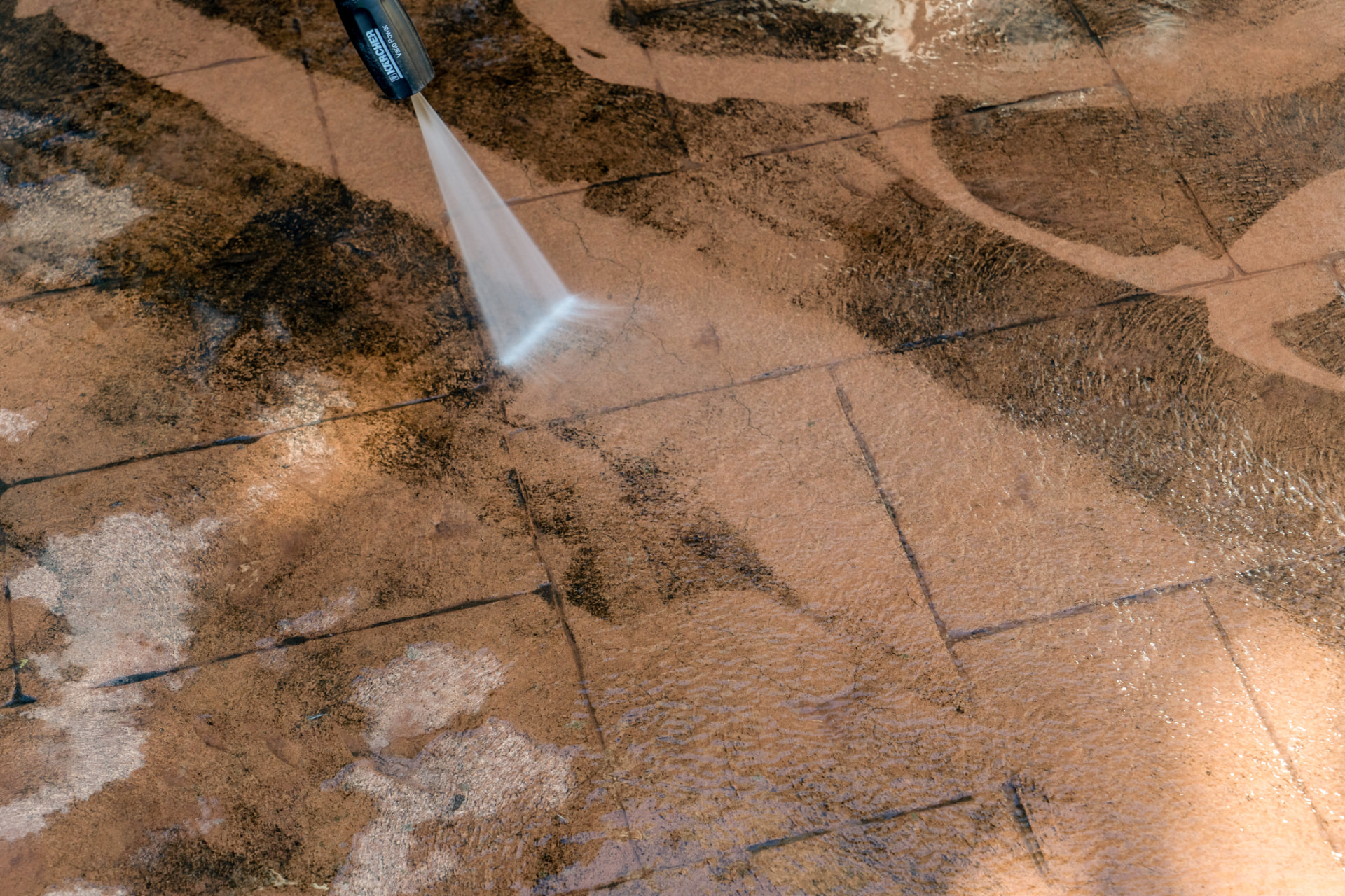 Pressure washing a stone patio in Alliance, Ohio showing the clean surface next to the dirty surface