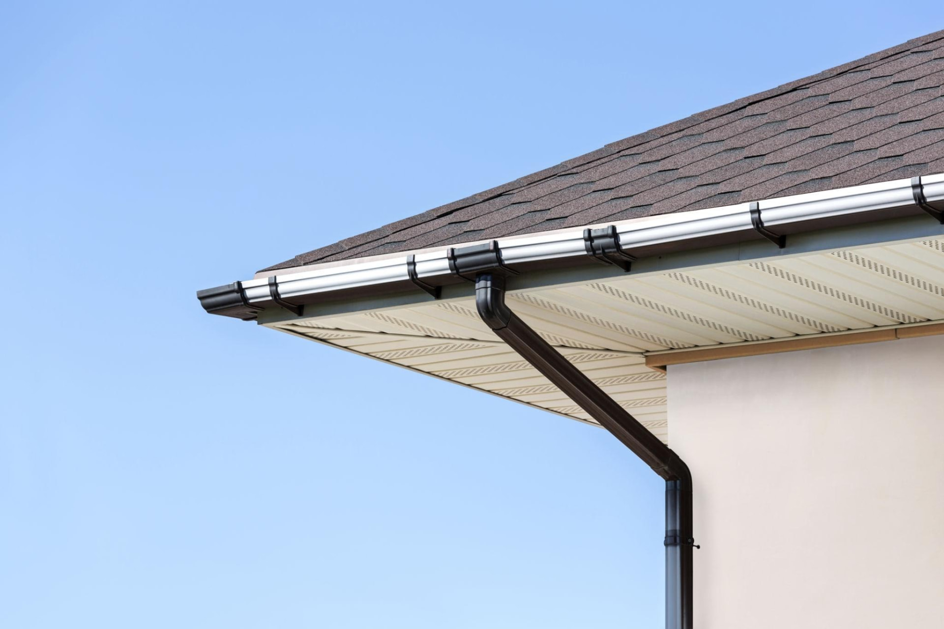 Clean gutters, soffit and downspout along a shingled roofline in Solon, Ohio