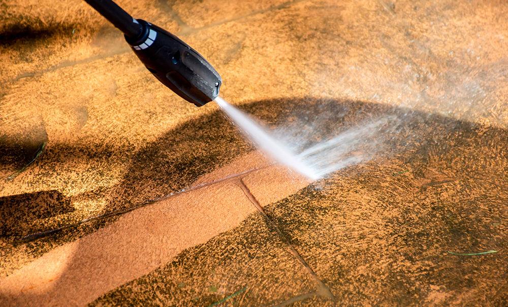Pressure washer stripping grime from a paved driveway in Alliance, Ohio