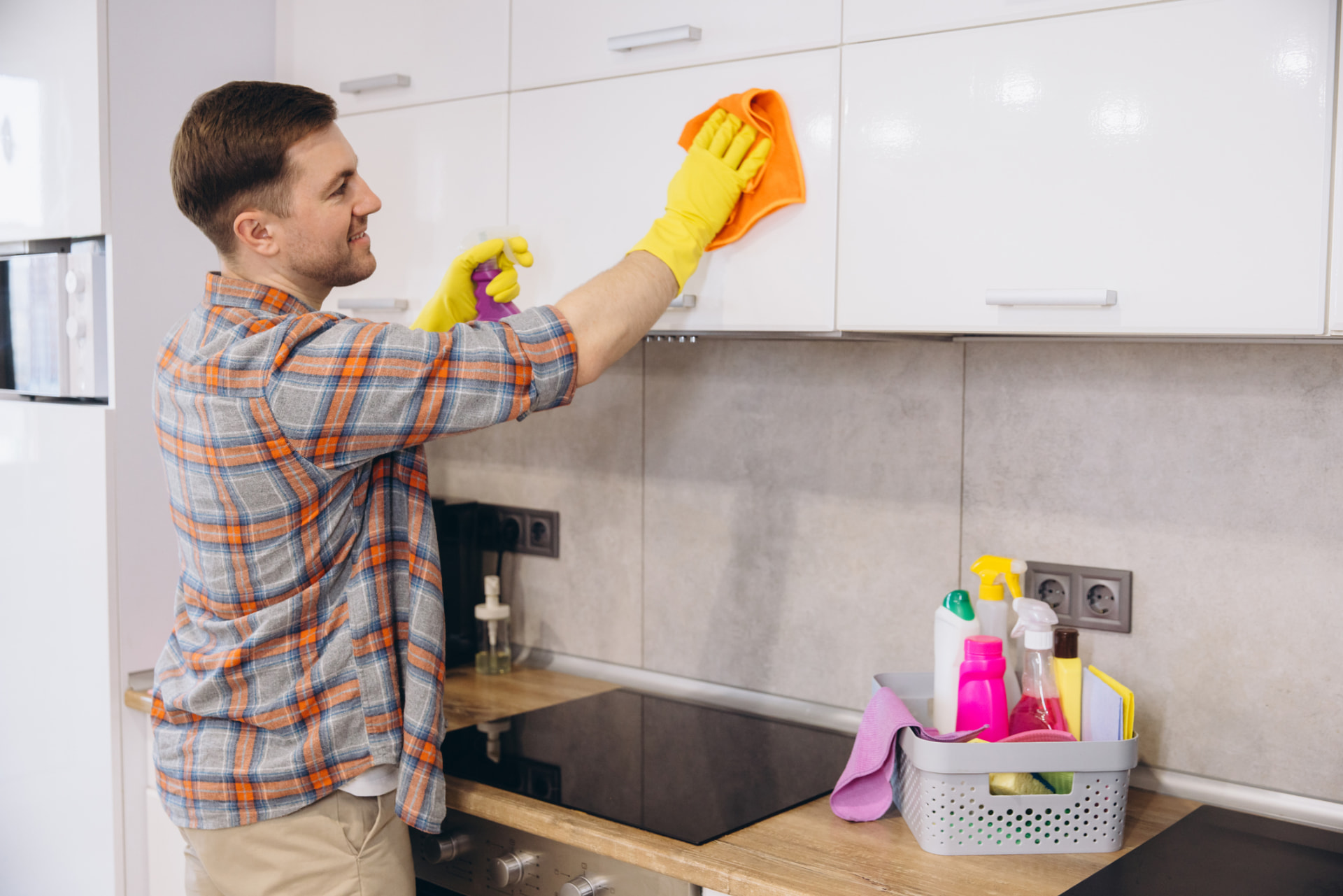 Cleaner wiping down kitchen cabinets during a move-out deep clean in Kent, Ohio