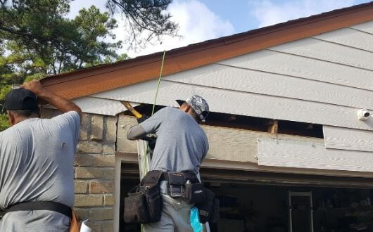Professional soft washing the siding of a modern home in Alliance, Ohio